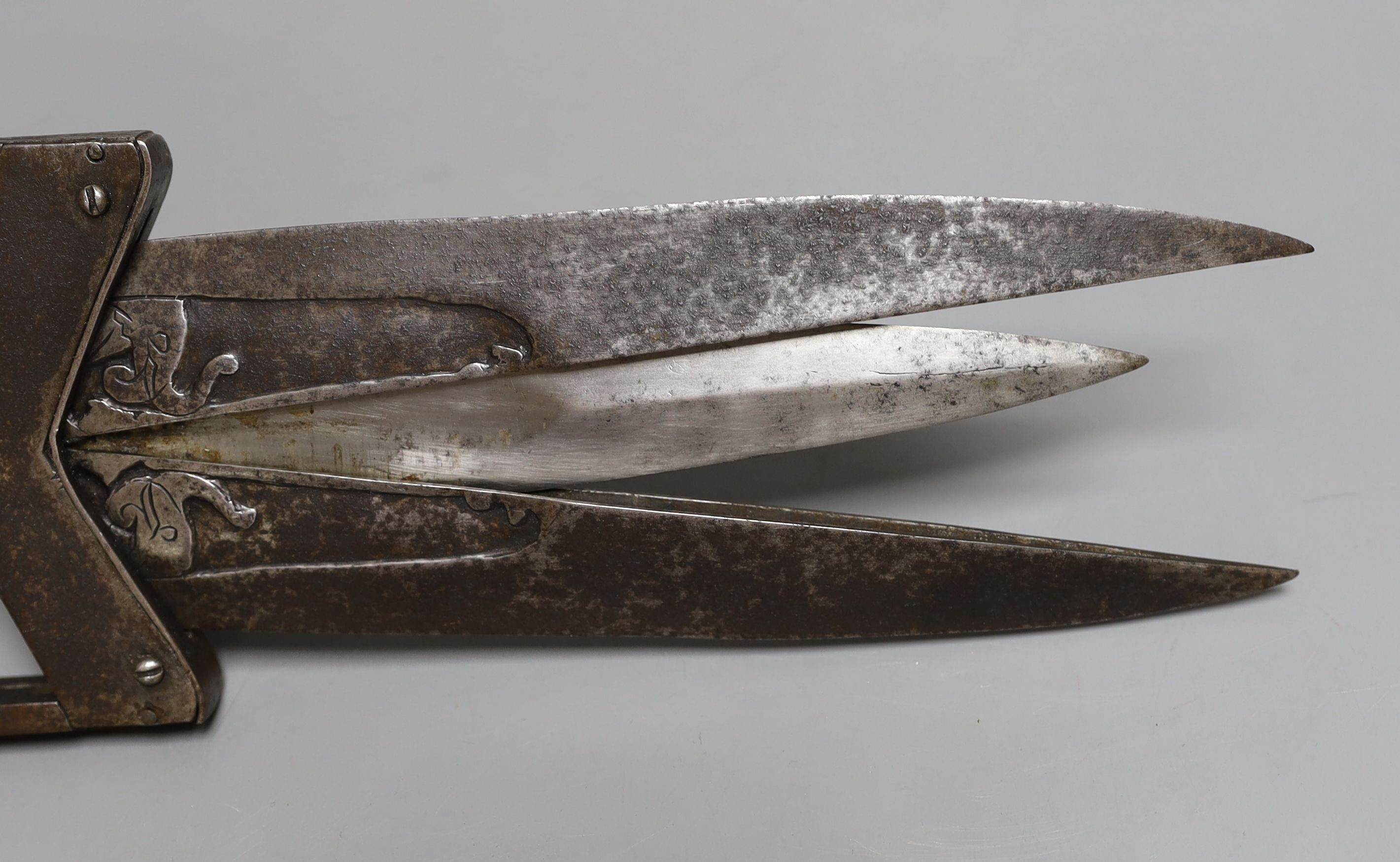 An Indian 19th century ‘scissors katar’, blades chiselled with elephant heads open to reveal an inner blade when grip is squeezed, overall length 40cms